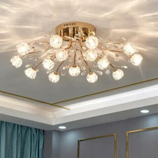 Photo d'un lustre plafonnier doré allumé à corolles en verre 15 branches avec ampoules de couleur blanc chaud dans un salon aux tentures vertes et moulures simples blanches au plafond