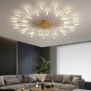 Photo d'un lustre plafonnier à plusieurs branches dorées en forme d'étoile ronde placé dans un grand salon au canapé d'angle gris clair, mur du fond gris foncé et un voilage devant la grande baie vitrée