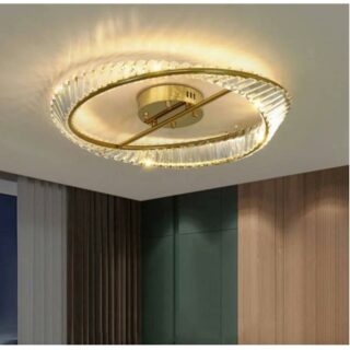 Photo d'un lustre plafonnier rond doré en forme de spirale avec une lumière jaune dans une pièce aux murs vert foncé et marron avec un pan de mur blanc à gauche sur un plafond blanc
