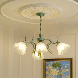 On voit un lustre vert sauge avec quatre suspensions en forme de tulipes blanches