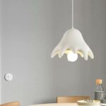 On voit un lustre pieuvre au dessus d'une table de cuisine