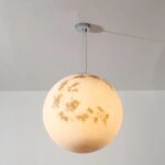 Photo d'un lustre en forme de lune dorée sur un fond gris clair et foncé