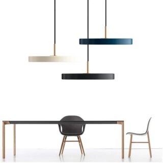 On voit trois lustres minimalistes au dessus d'une table