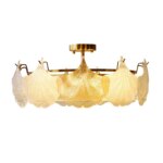 Lustre plafonnier avec des coquillages en verre sur fond blanc.