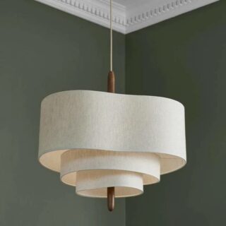 Photo d'un lustre chic au design japonais en tissu beige clair à trois étages de taille différente, un manche de bois marron foncé au centre du lustre, le tout suspendu dans une pièce aux murs vert foncé et au plafond à moulures blanches