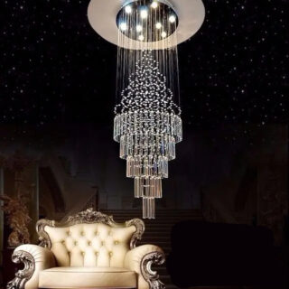 Photo d'un lustre d'escalier suspendu à un large plafonnier à neuf ampoules au dessus d'un fauteuil blanc style ancien le tout sur un fond noir