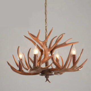 On voit un lustre rustique en bois branches avec des ampoules en forme de bougies.