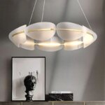 Lustre pendant avec plusieurs abats jours dans une pièce avec des murs gris.