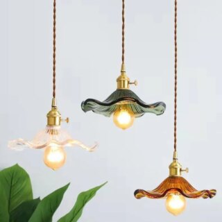 Lustres pendants avec abats jours en verre sur fond gris.