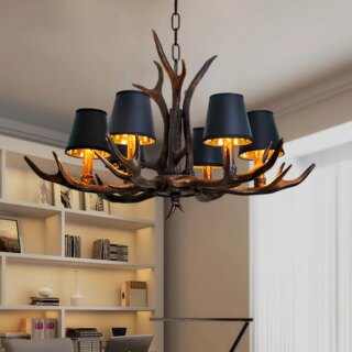 On voit un lustre en bois de cerf avec six lumières dans une pièce joliment décorée