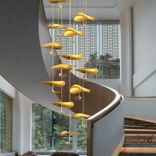 Lustre XXL doré dans une cage d'escalier.